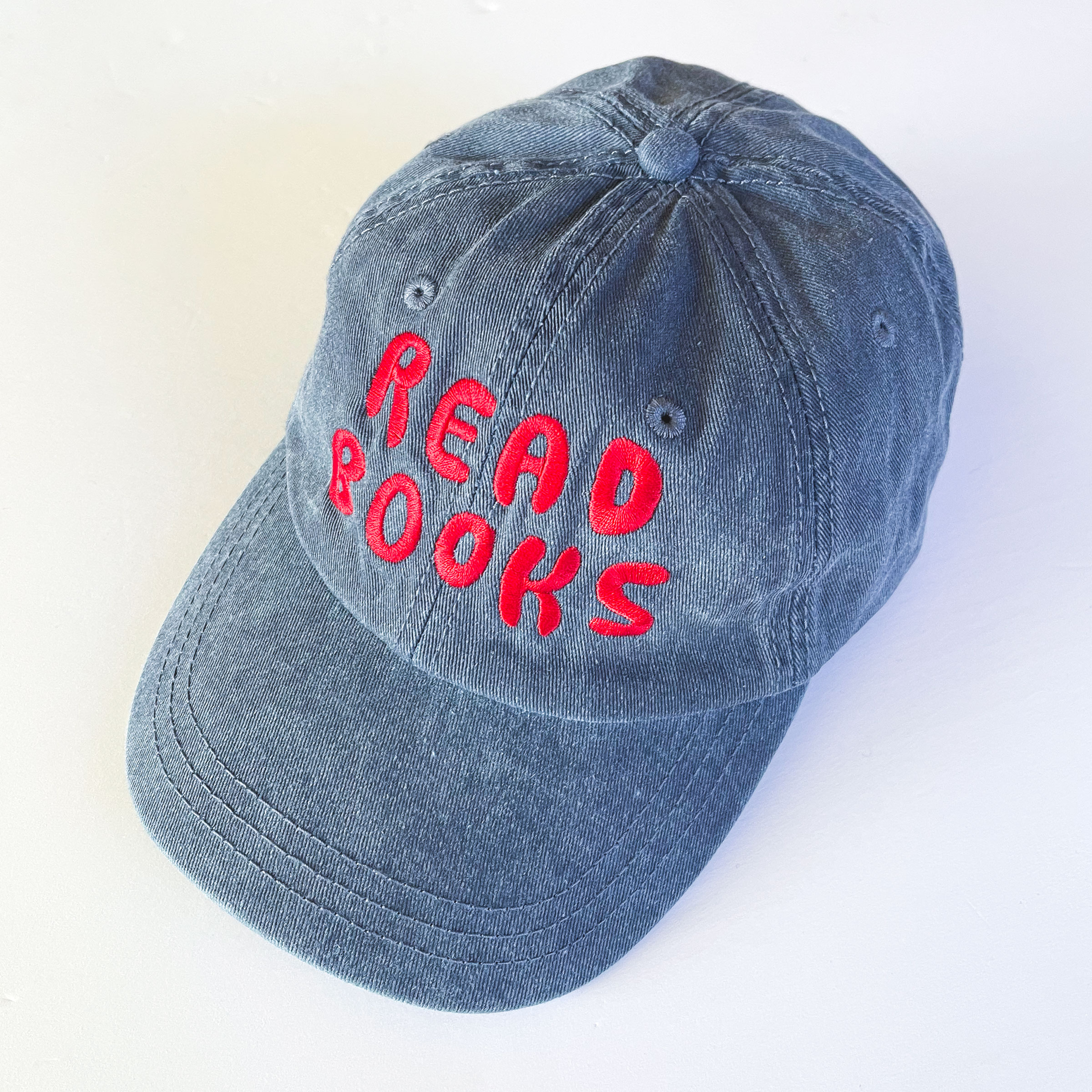 dark blue stone-washed cap embroidered with "read Books" in glossy red thread