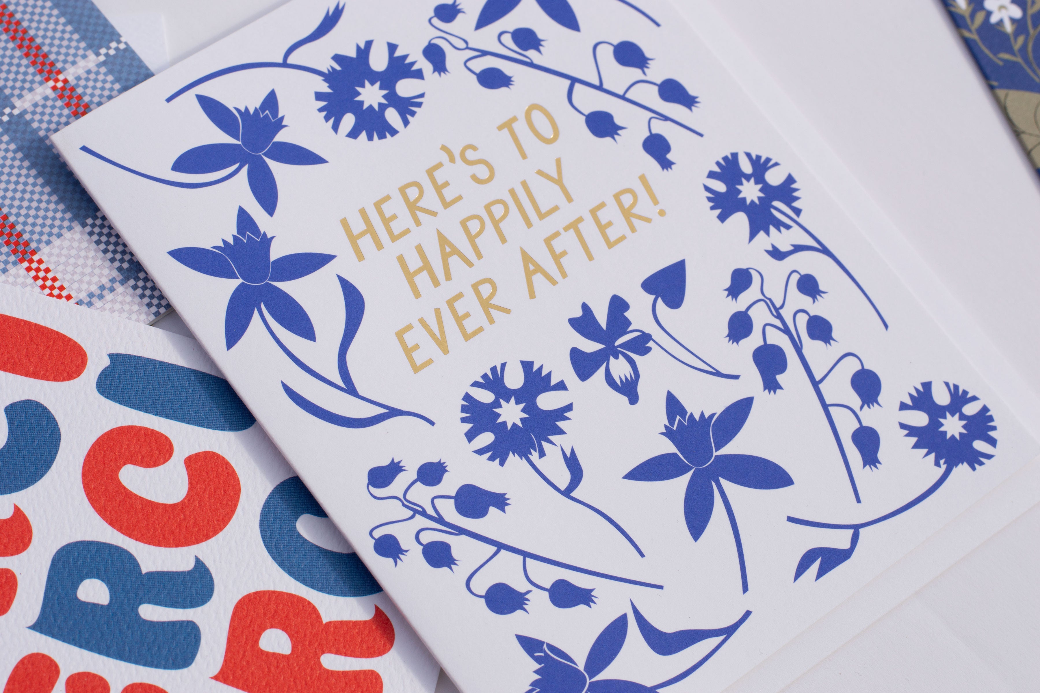 Metallic gold foil Here's to Happily Ever After with chalk blue flower silhouettes