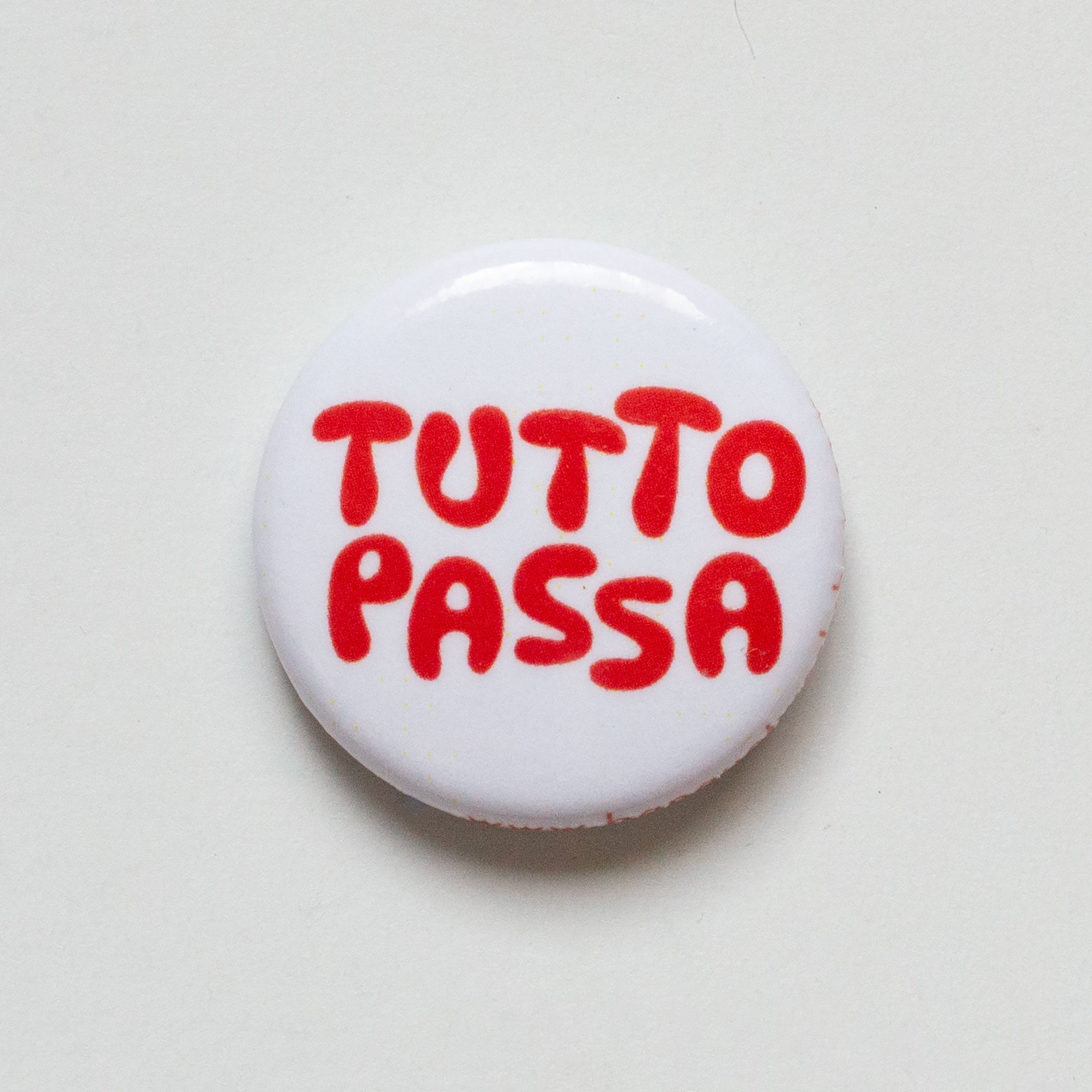 1" button read Tutto Passa in red bubble letters on a white background