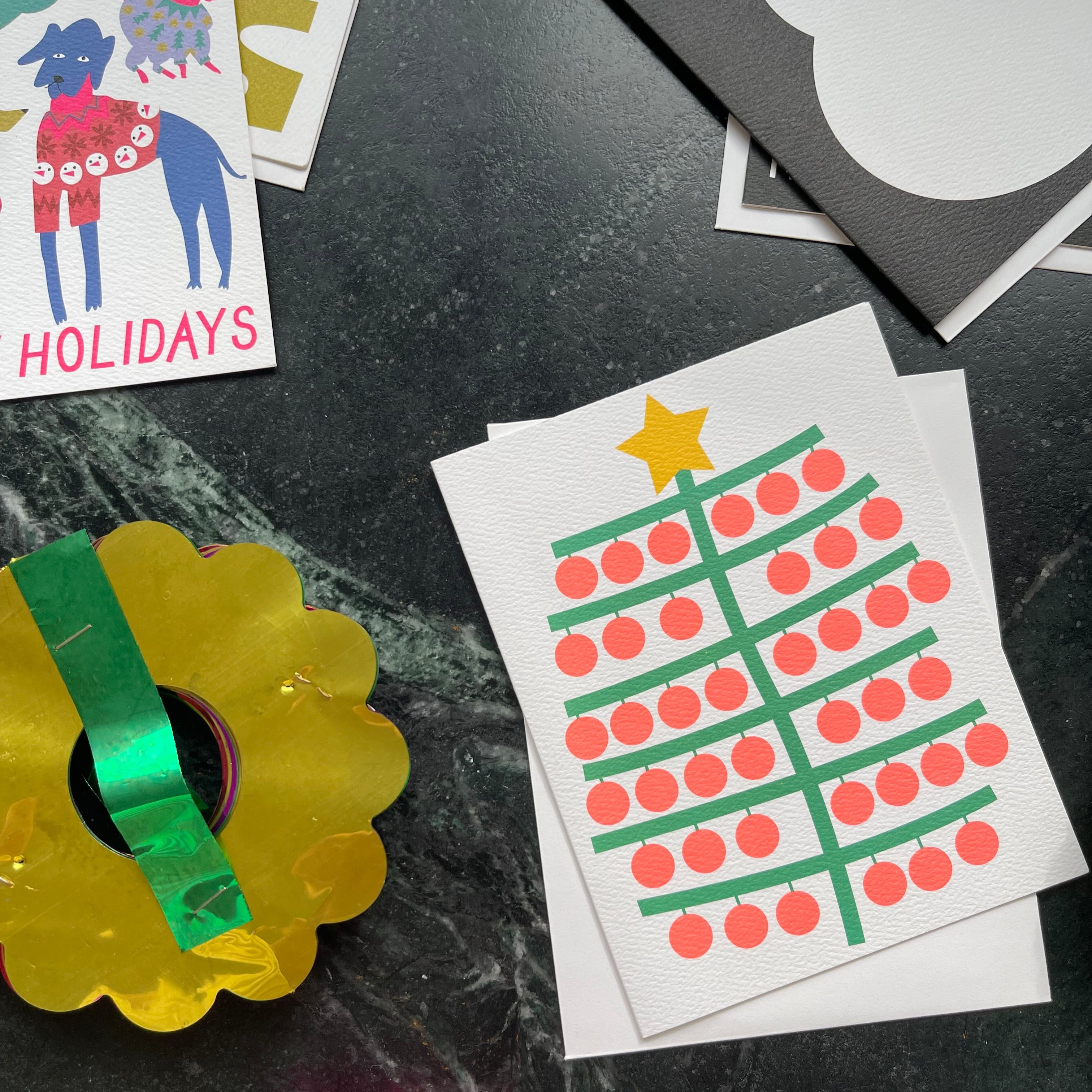 Colorful holiday cards and decorations on a dark surface