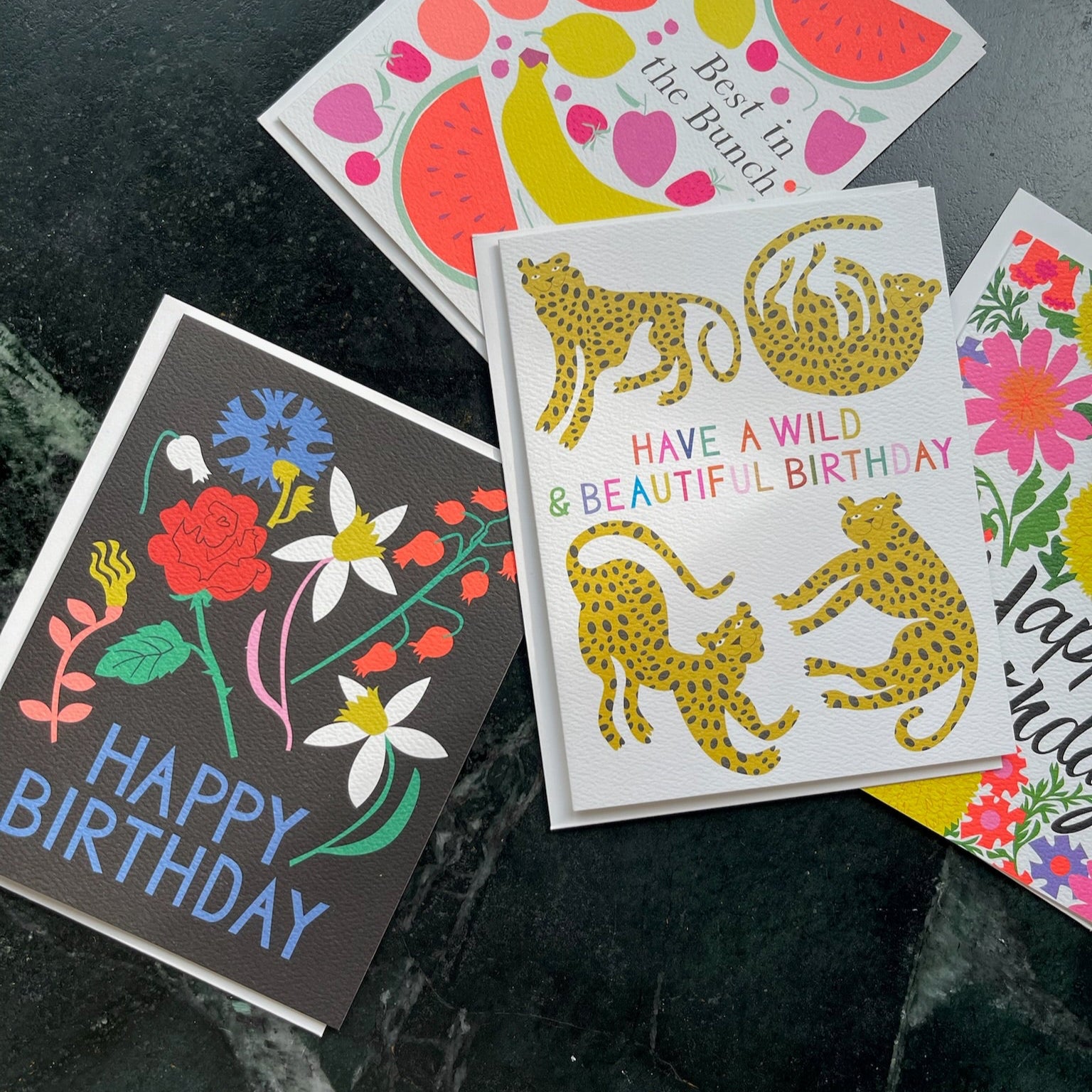 Collection of colorful birthday cards on a dark surface