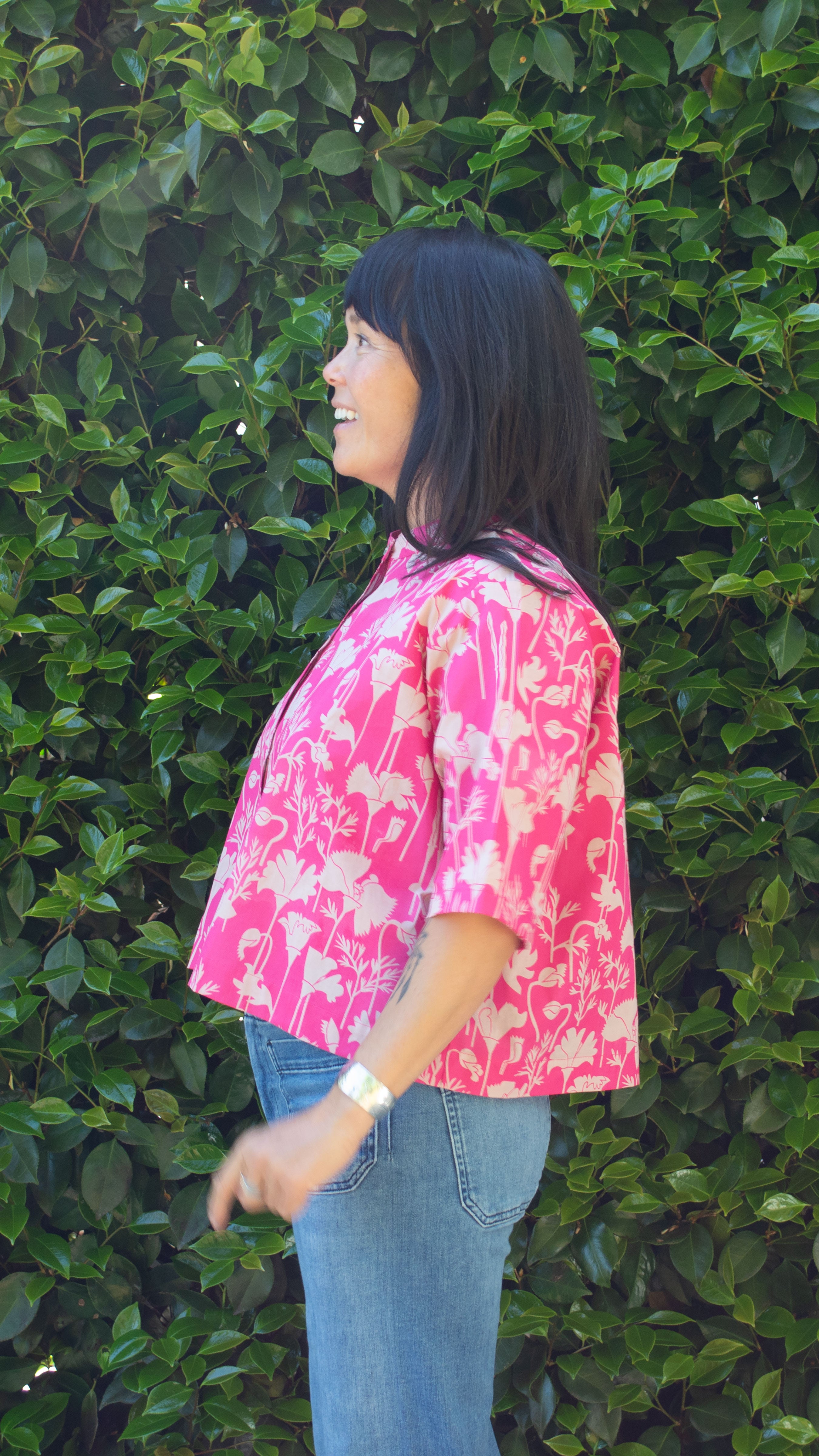 Side view of Raspberry pink California printed poppy button down shirt crop top