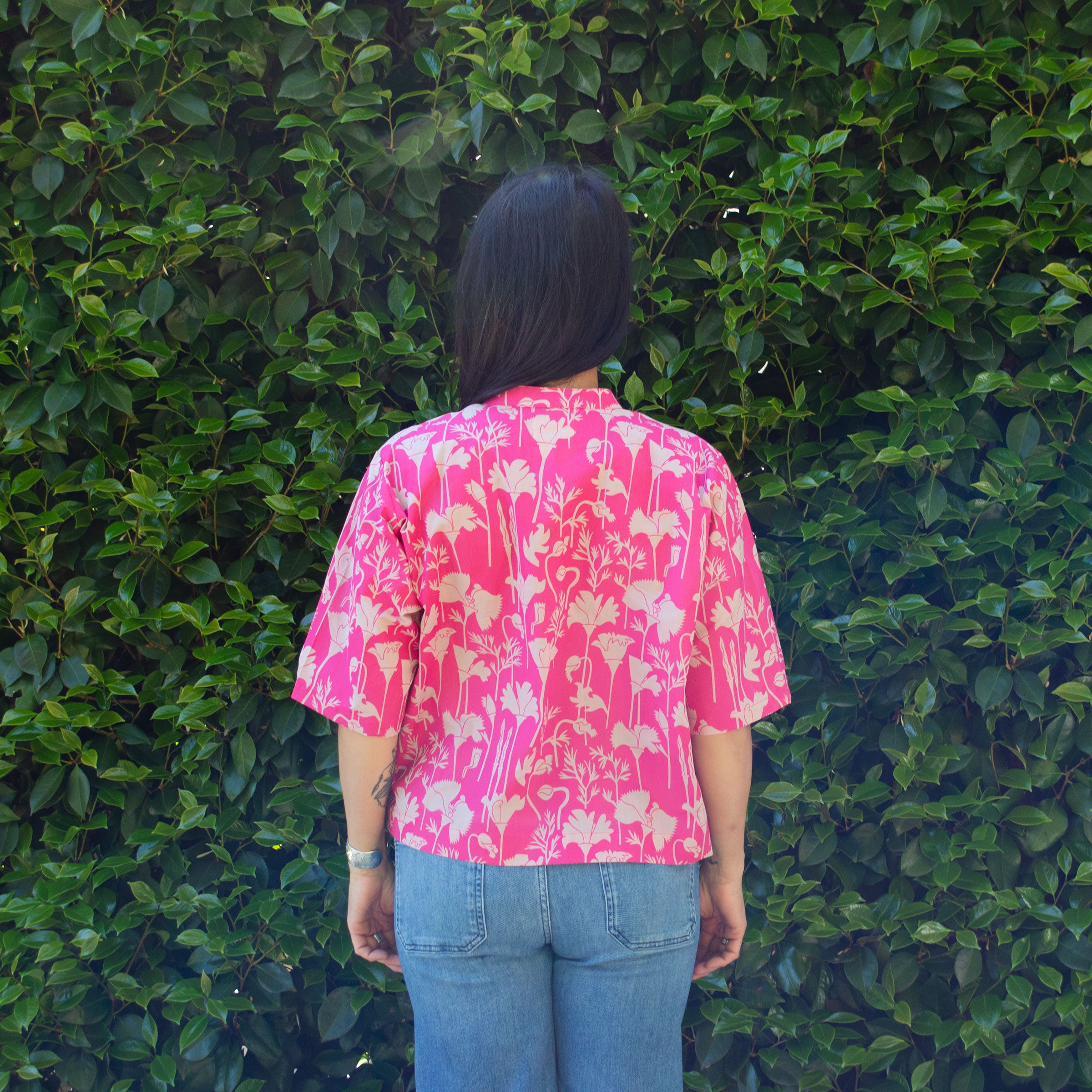 Back view of Raspberry pink California printed poppy button down shirt crop top