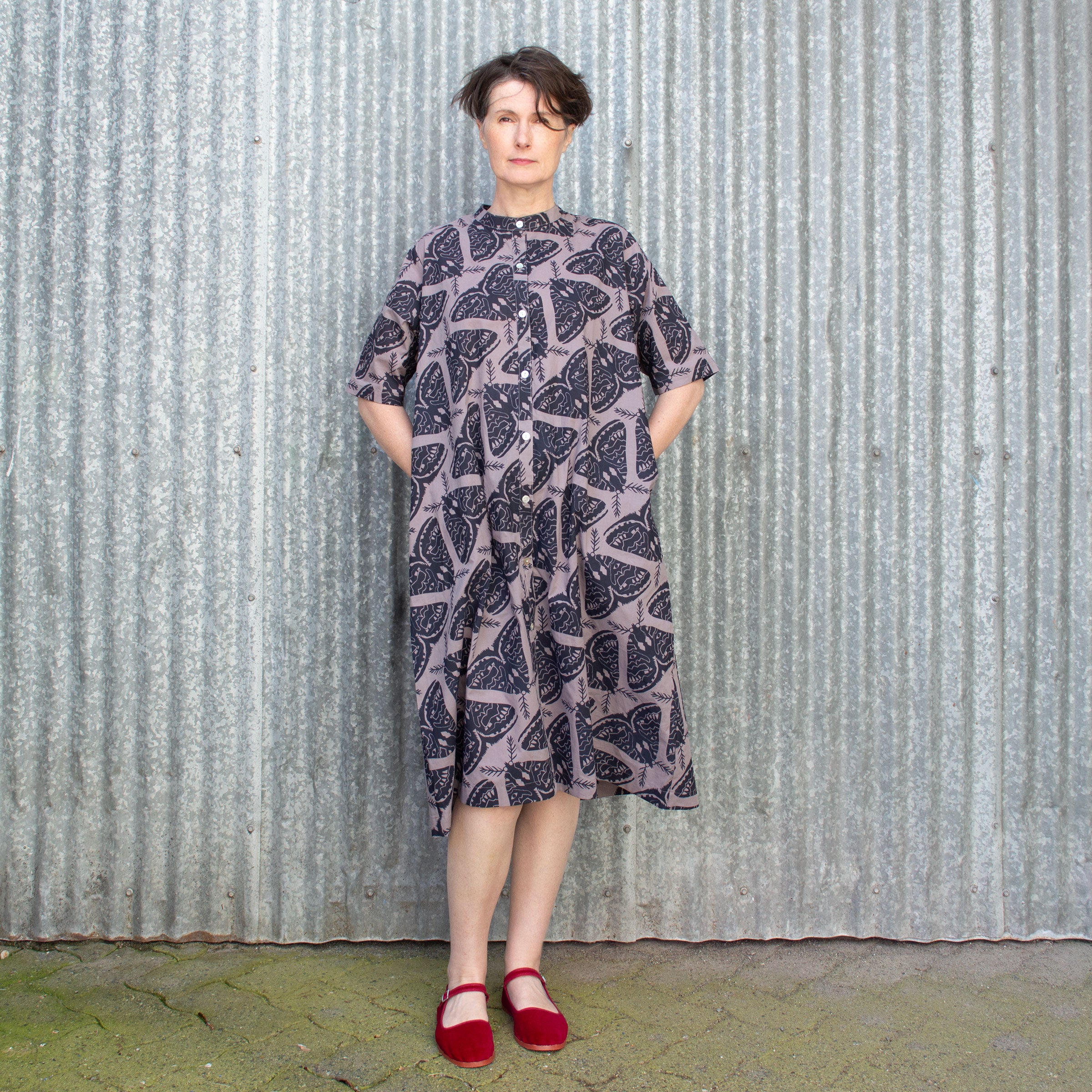 Lovely woman wears a button from shirt dress with classic band collar and printed with moths. Also includes pockets!