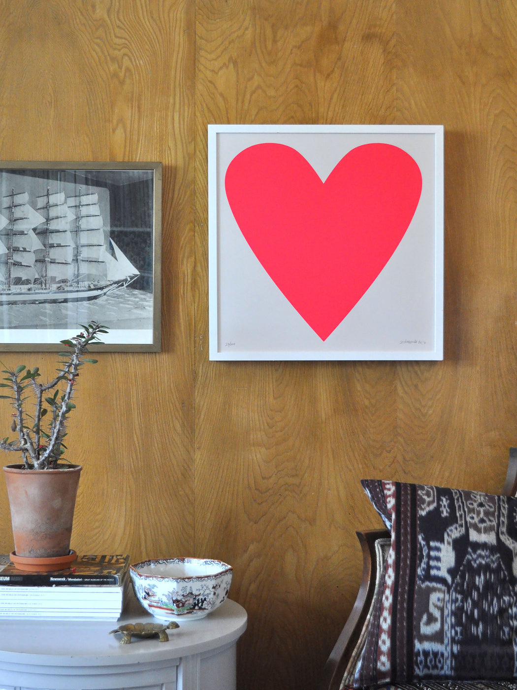 Styled shot of Banquet Workshop's iconic neon red heart with a tall ship and ikat.