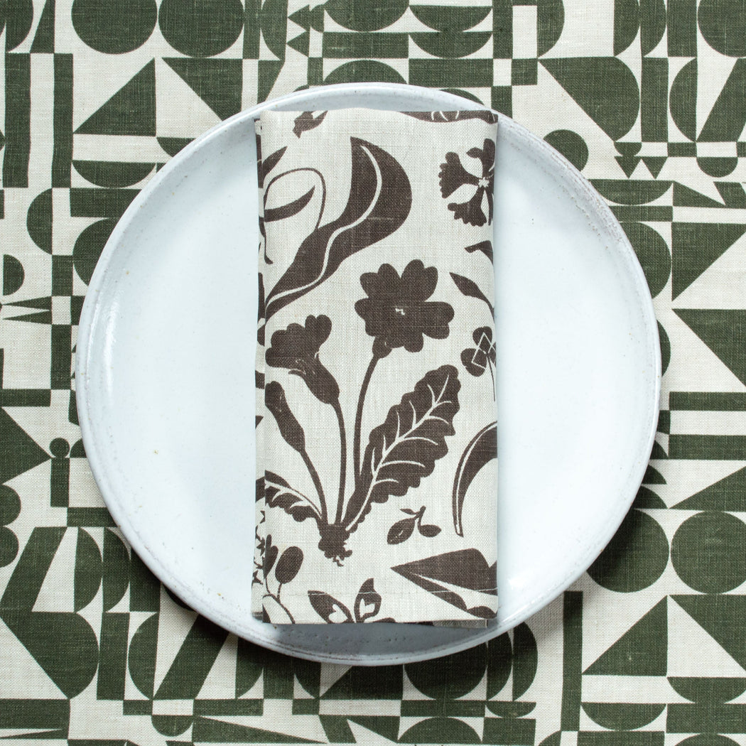 chocolate brown wildflowers print on natural linen on a white plate  green geometrics on natural