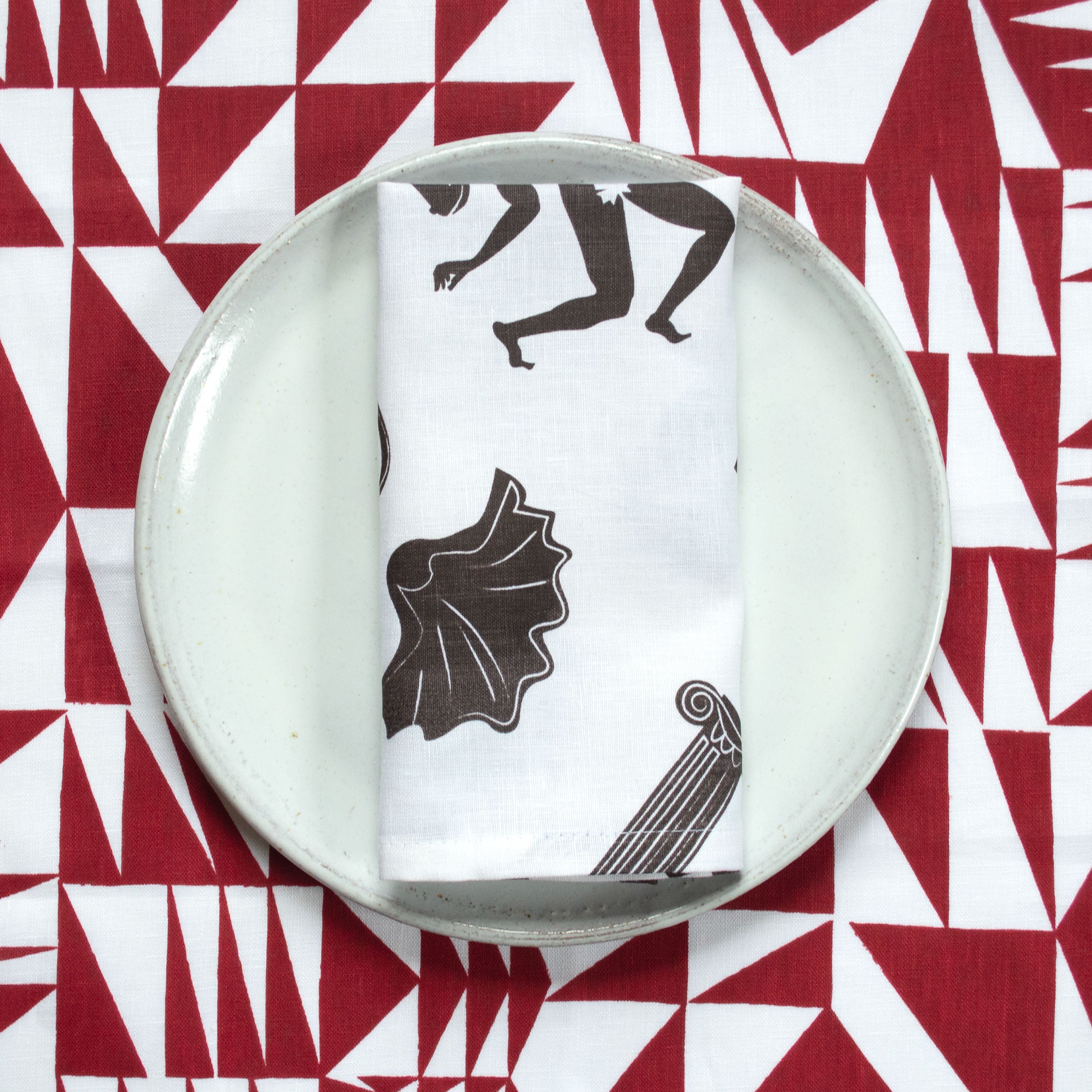 linen napkin ancient pattern on white plate with red triangle pattern in background