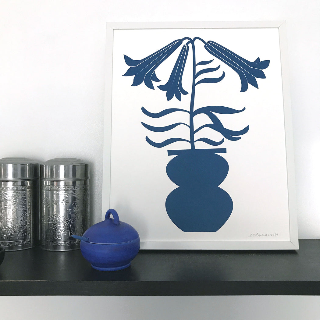 Framed print of a blue blooming lily stem in a vase