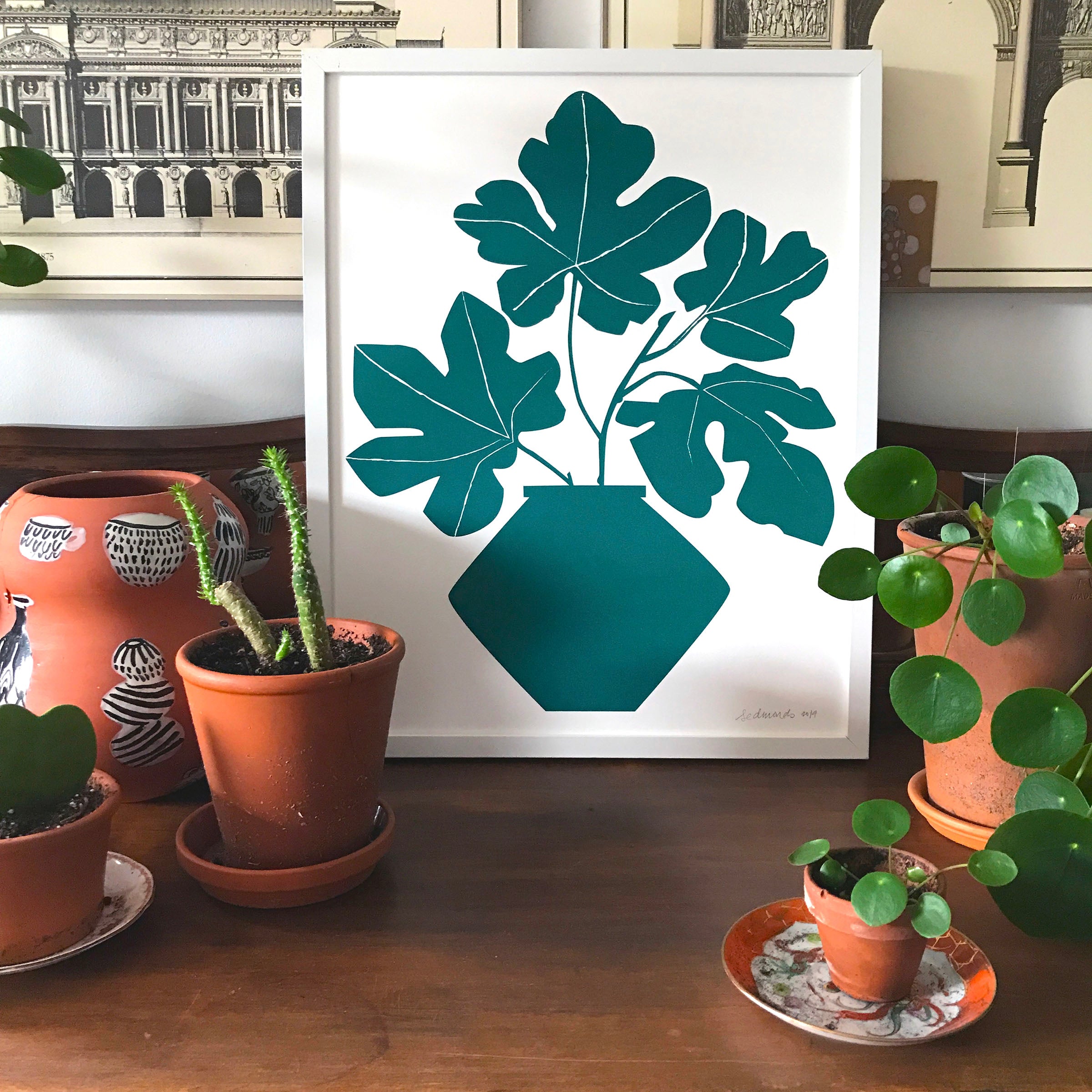 framed fig print surrounding by house plants