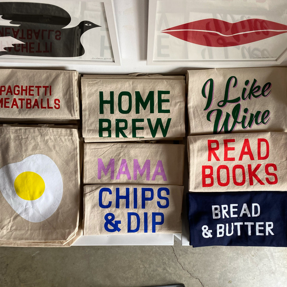 Read Books Tote Bag in Red Text with a huge bookshelf filled with many books