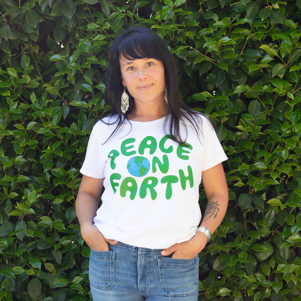 Beautiful Woman in a 70s Peace on Earth t-shirt featuring a big blue and green illustration of our planet Earth