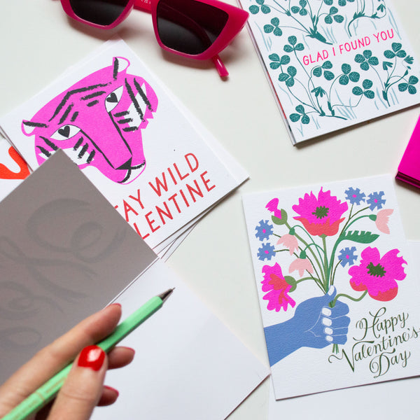 valentines day cards including a violet tiger, a handheld bouquet, and green clover