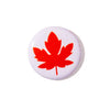 A round white button pin featuring a bold red maple leaf design, shown on a clean white background.