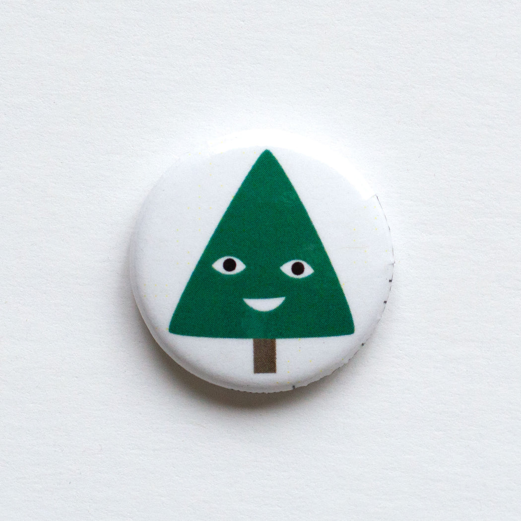 holiday themed 1" button with a smiling christmas tree