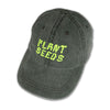 khaki ball cap embroidered in wiggly neon yellow letters that read Plant Seeds
