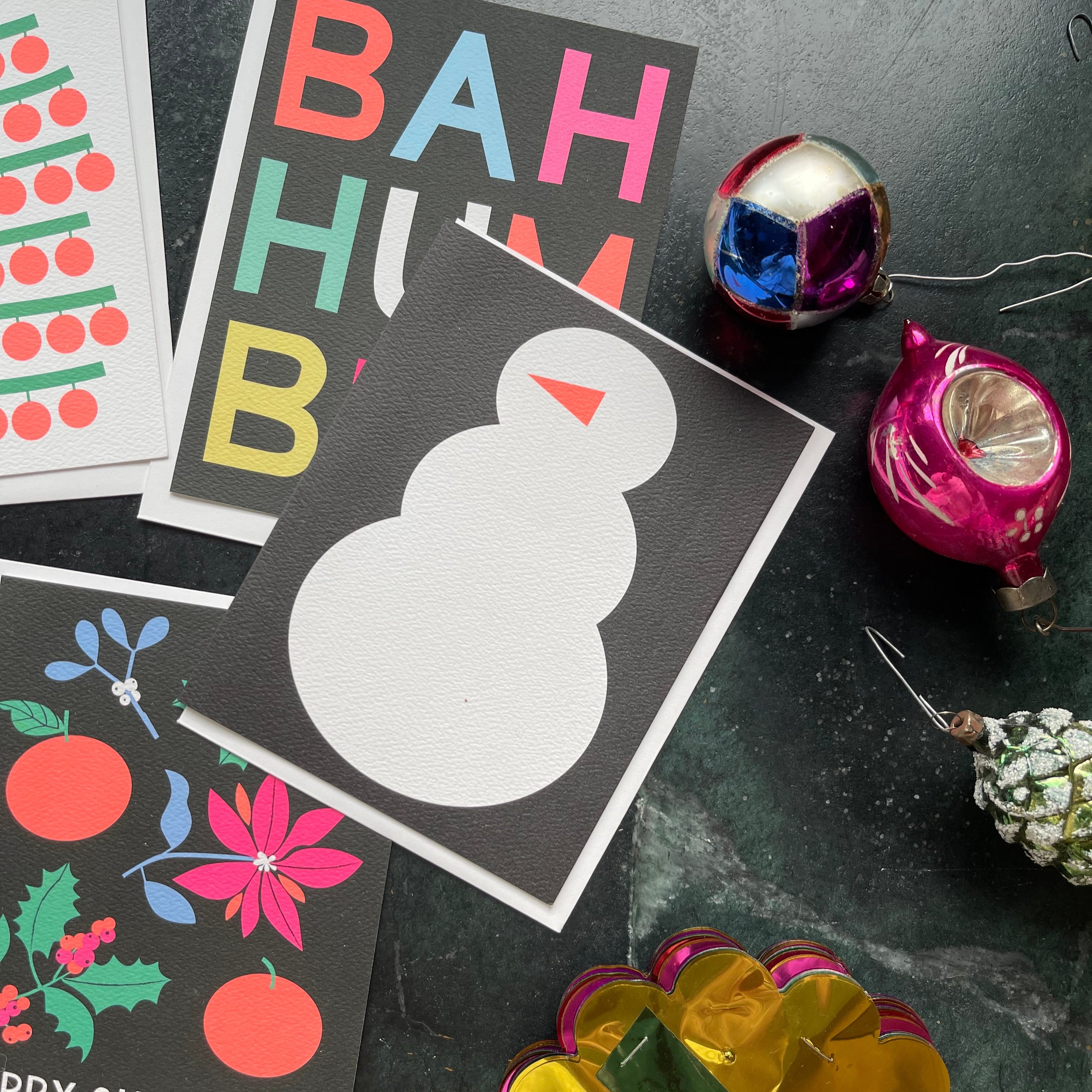 holiday cards including a minimalist snowman on a dark background