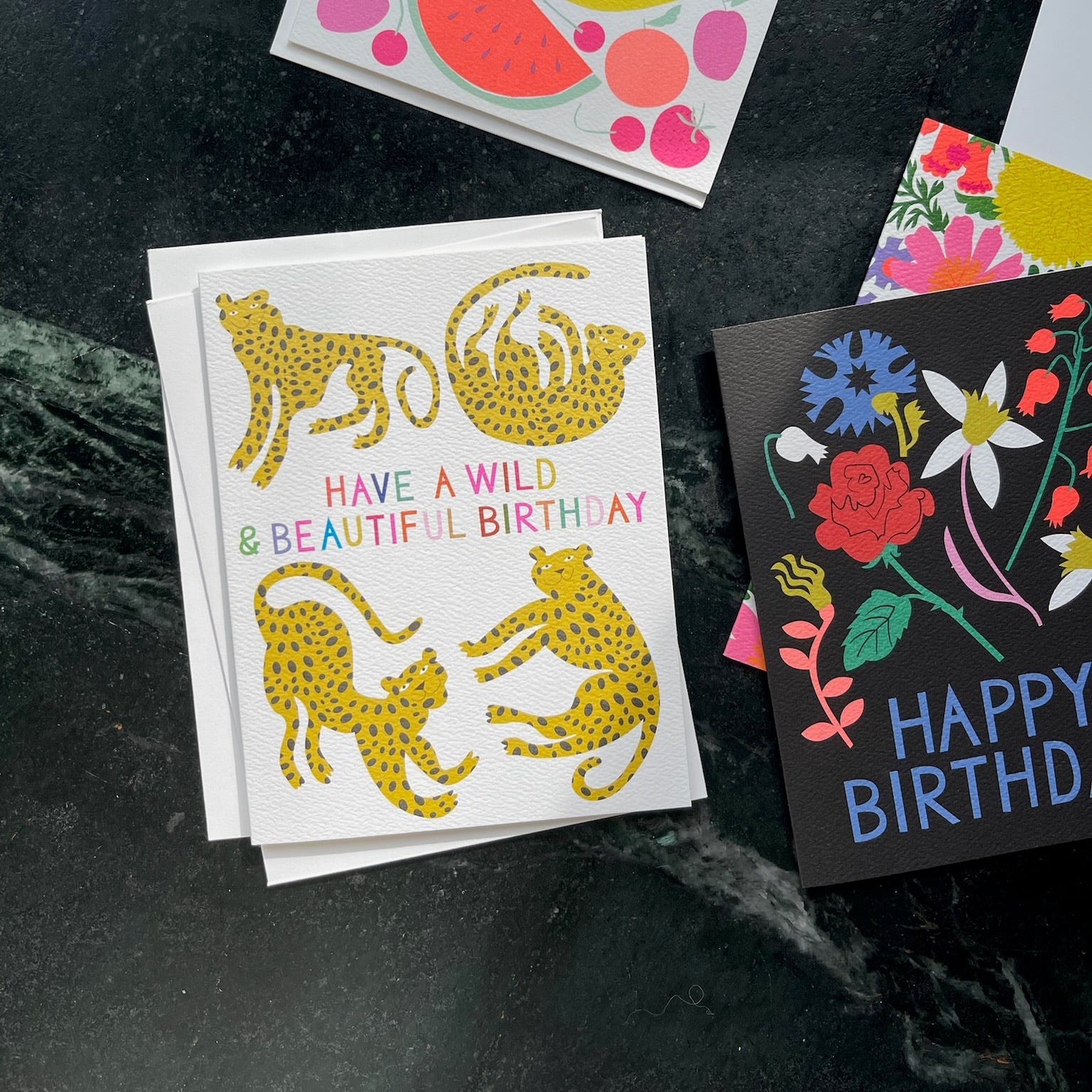 Collection of colorful birthday cards on a dark surface
