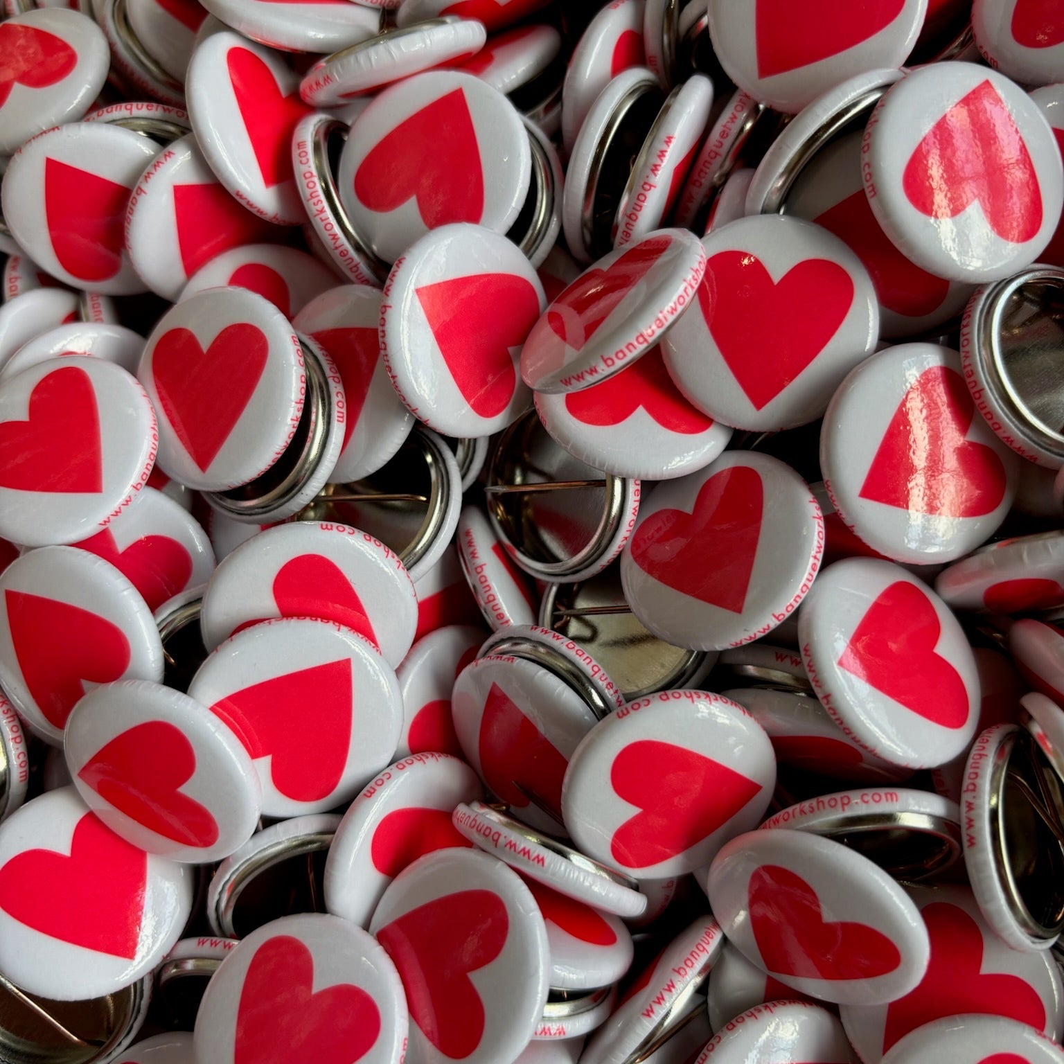 Collection of buttons with neon heart designs on a white background