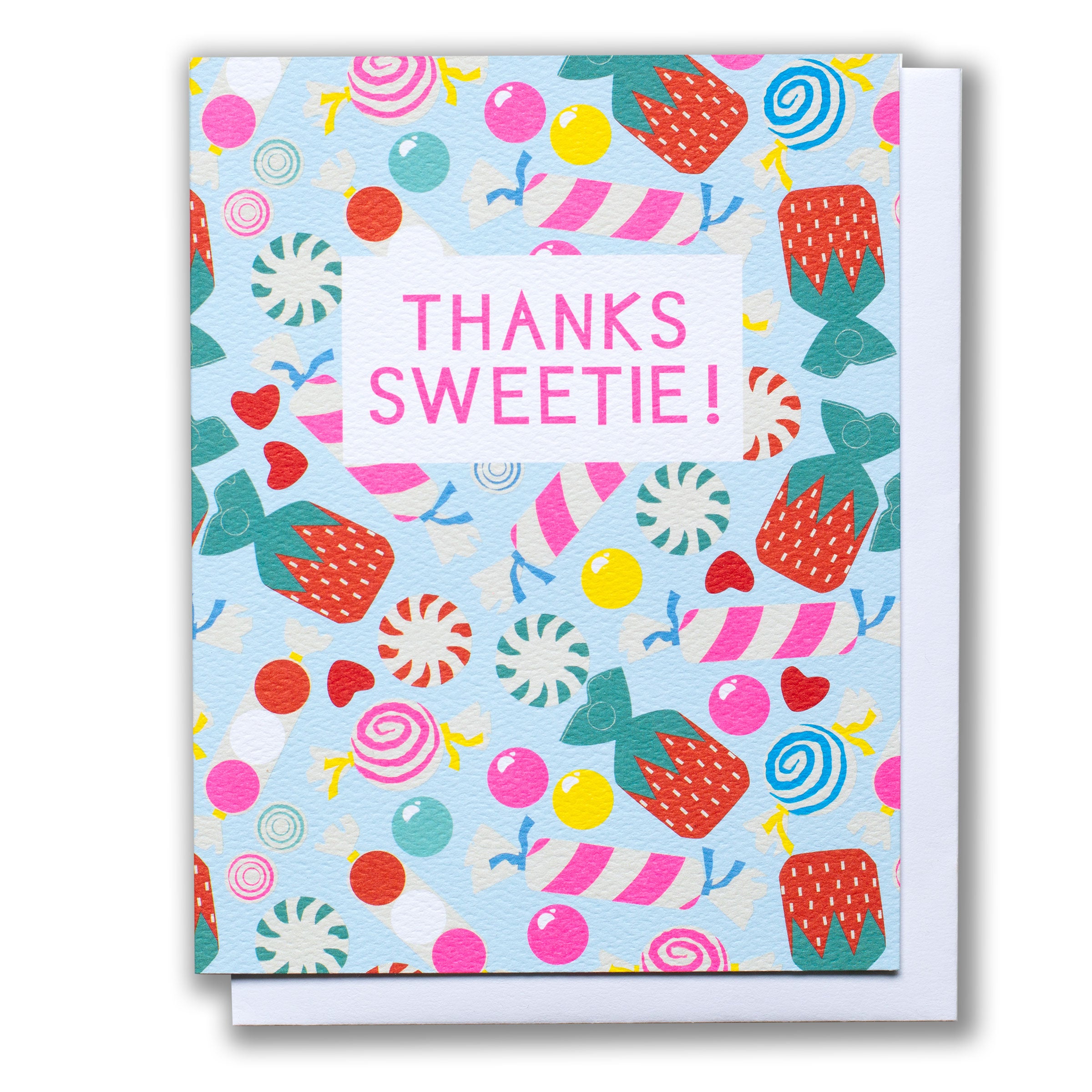 Note card reads Thanks Sweetie on a scattered field of candies in every colour, swirl and stripe.