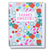Note card reads Thanks Sweetie on a scattered field of candies in every colour, swirl and stripe.