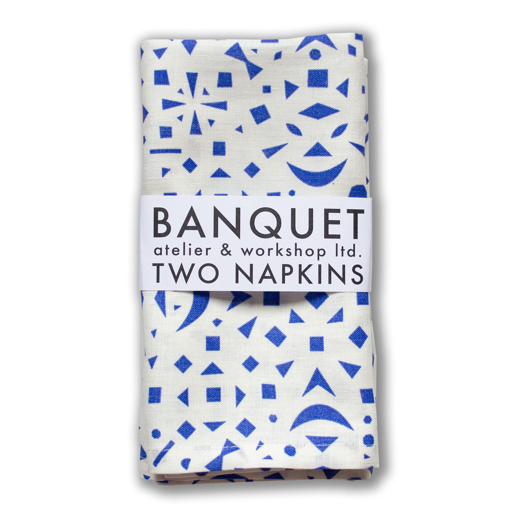 napkins printed with a scattering of tiny cobalt blue geometric shapes