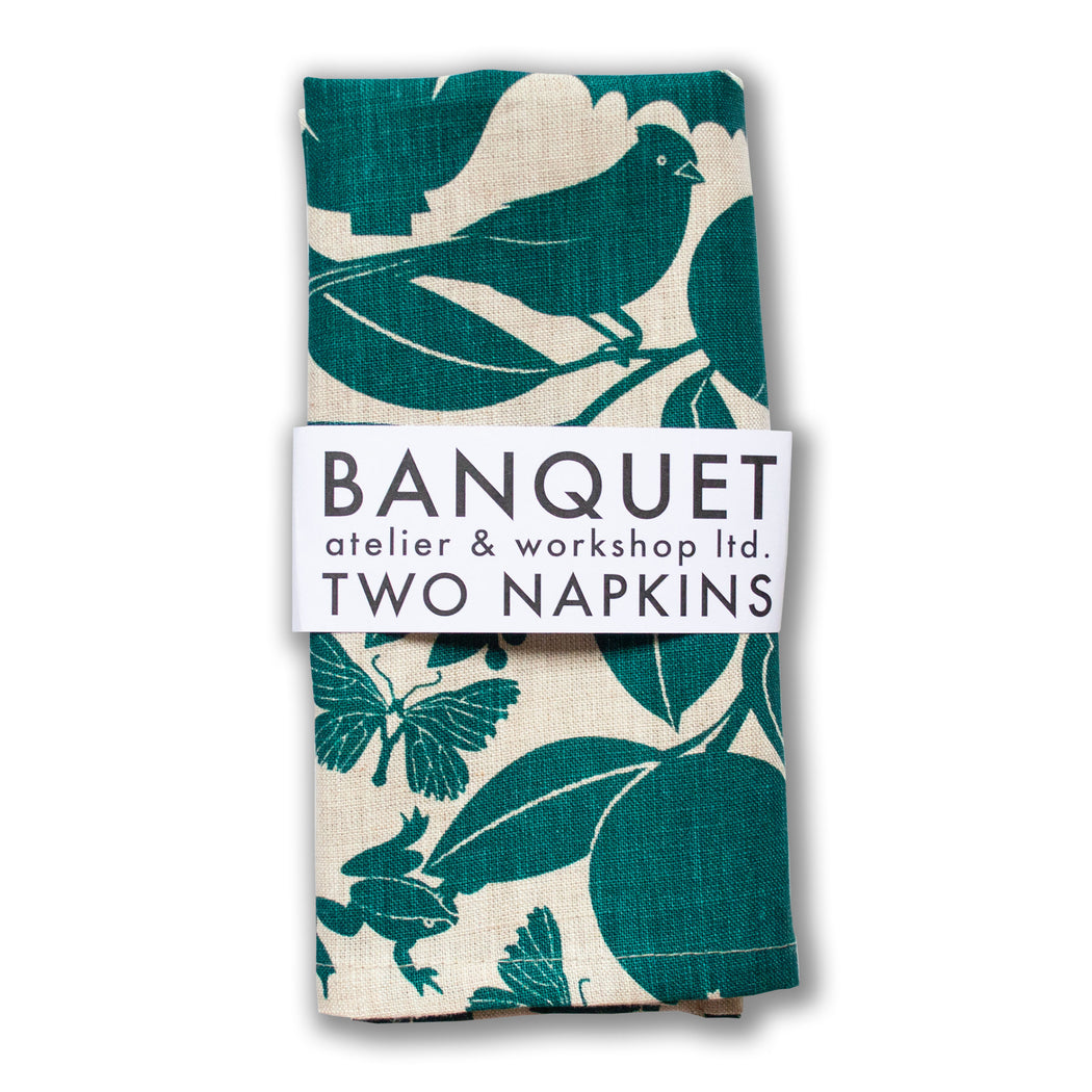 napkins printed with emerald green birds, orange and lemon branches, butterflies, frogs and more