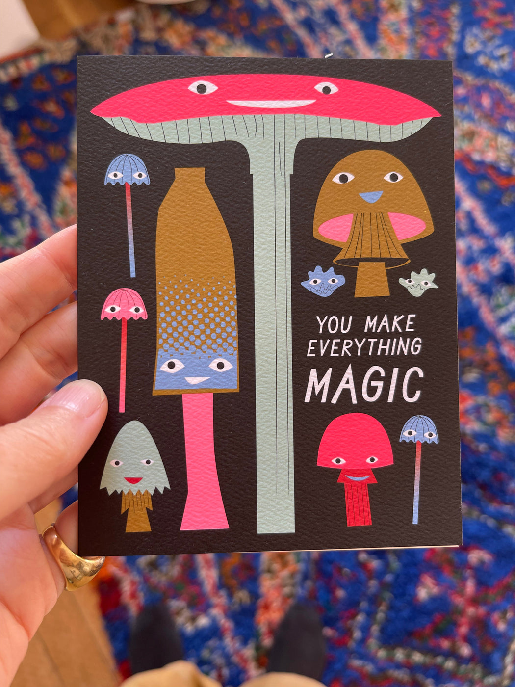 A special note cards with a crowd of fungi with grinning faces and the greeting "You Make Everything Magic"