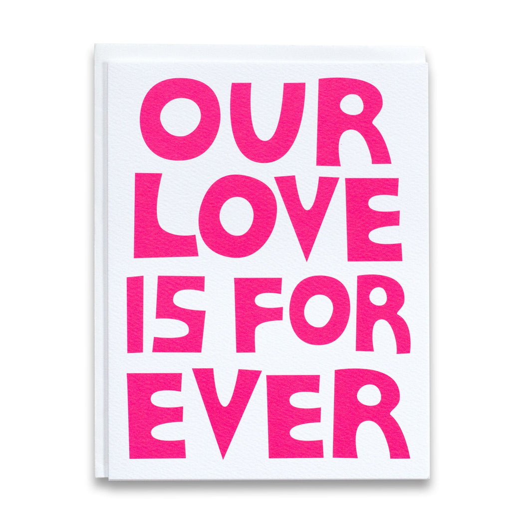 Card with neon pink block letters reading "Our Love is Forever"