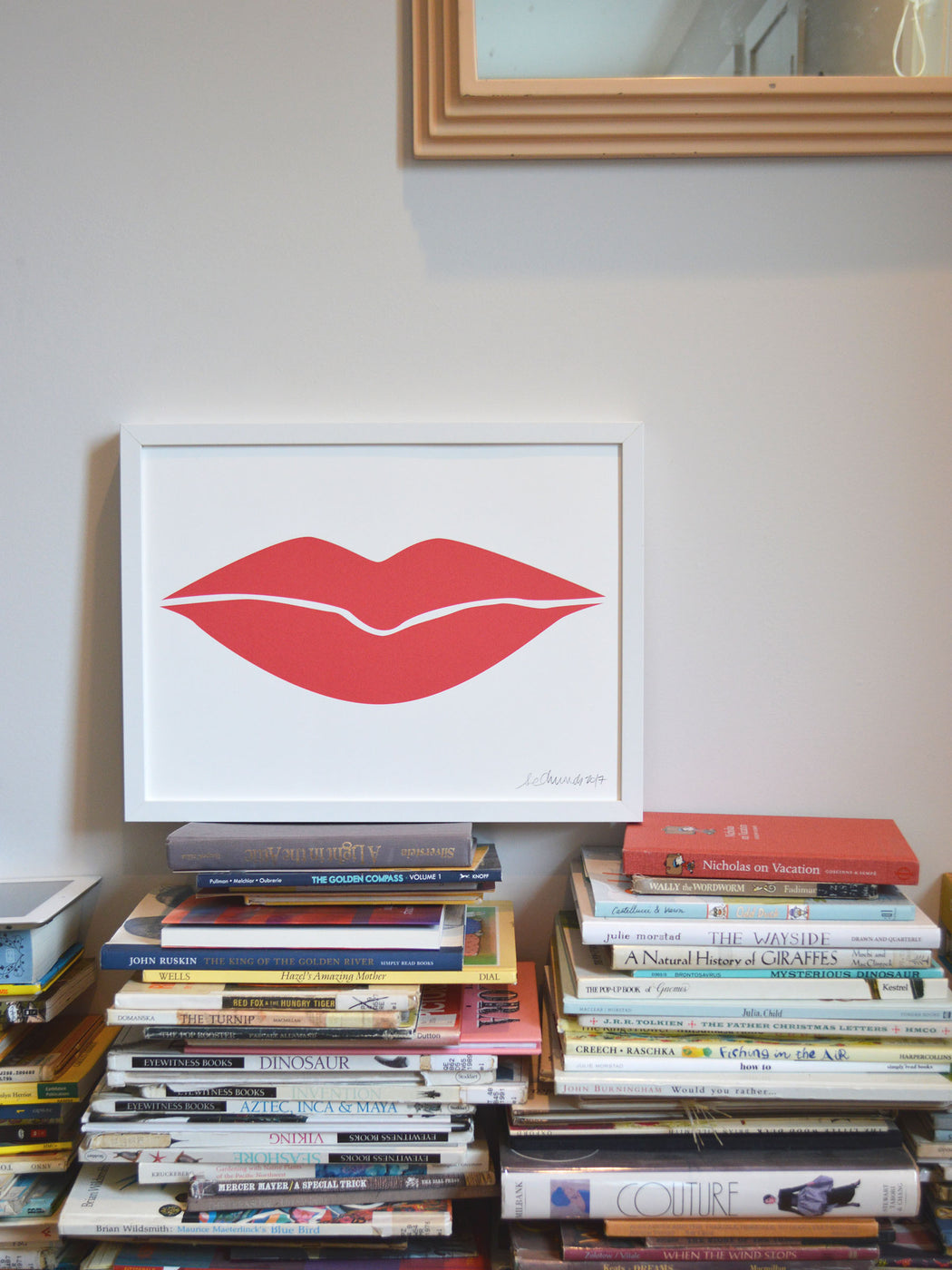Banquet Workshop's lip print sitting on a stack of books in a home